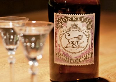 eine Flasche Monkey 47 Schwarzwald Dry Gin mit zwei Gläsern