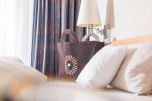 Detailaufnahme vom Bett und einer bedruckten Stofftasche mit dem Logo des Schwarzwald Panoramas