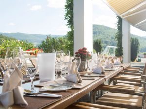 A dining table on the terrace of the wellness hotel SCHWARZWALD PANORAMA, offering a breathtaking view of the black forest