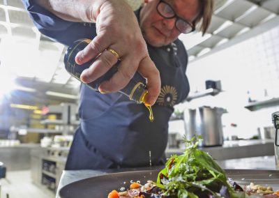Chef in the Black Forest Panorama drizzled a ready-made salad with high-quality oil
