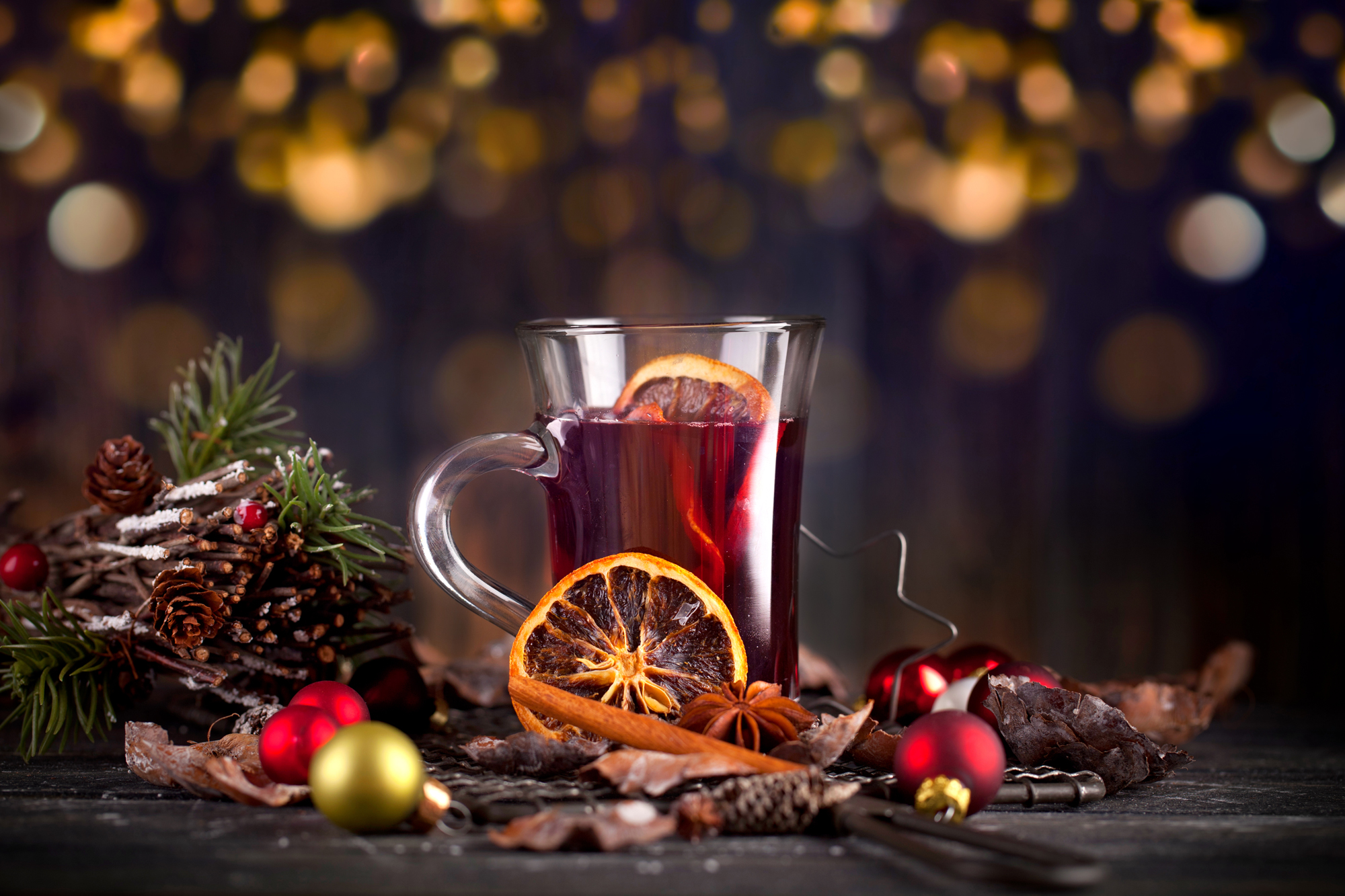 Glühwein weihnachtlich arrangiert mit Orangen, Zimtstange, Sternanis und Tannenzweigen
